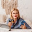 Kobieta w ręku trzyma telefon i kartę kredytową